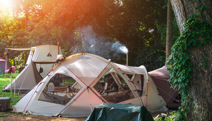 Wall Mural - morning sunlight on surface of various field tents group in camping area at natural parkland