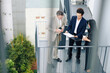 © DragonImages - Confident serious entrepreneur showing report with financial data to colleagues when they are standing on fire escape staircase