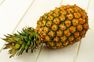 Canvas Print - Exotic fruits. Ripe sweet ripe pineapple on wooden background. Studio Photo