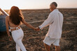 © Alejandro Diaz/ADDICTIVE STOCK - Back view of couple of travelers holding hands while walking in savanna at sunset during summer vacation
