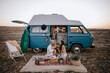 © Alejandro Diaz/ADDICTIVE STOCK - Side view of traveling couple sitting on blanket near van in savanna and having picnic while enjoying summer vacation and looking at each other