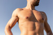© Andres Victorero/ADDICTIVE STOCK - Determined male athlete with strong naked torso standing on grassy hill on sunny day in summer and looking away