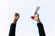 © David Munoz/ADDICTIVE STOCK - Unrecognizable crop African American male with red and white megaphone standing with fist up on white background