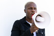 © David Munoz/ADDICTIVE STOCK - Cheerful African American male shouting in loudspeaker while standing on white background