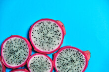 Top View Of Full Frame Background Of Round Pieces Of Sweet Juicy Pitaya Fruit Placed On Blue Background In Studio