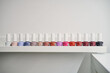 © Gabriel Trujillo/ADDICTIVE STOCK - Set of colorful nail lacquers placed in row on shelf in modern beauty studio
