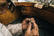 © Ioritz Lopez/ADDICTIVE STOCK - Side view of crop unrecognizable male goldsmith in glasses holding tweezers with diamond while creating jewelry accessory at workbench