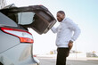 © Jake Jakab/ADDICTIVE STOCK - Side view of African American male opening trunk of modern car before driving