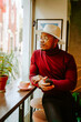 © Jake Jakab/ADDICTIVE STOCK - Pensive African American male in stylish outfit sitting at counter in coffee shop while chilling at weekend and looking out of window