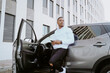 © Jake Jakab/ADDICTIVE STOCK - African American male standing near expensive car and surfing Internet on smartphone