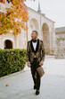 © Jake Jakab/ADDICTIVE STOCK - Elegant African American male wearing expensive tuxedo walking along street and looking away