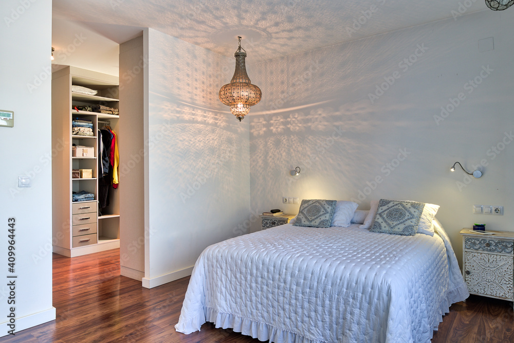 Interior of cozy bedroom with big white bed and classic chandelier ...