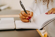 © Jake Jakab/ADDICTIVE STOCK - Crop unrecognizable female entrepreneur sitting at table with laptop and writing plan for business project in notebook