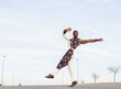 © Jose Carlos Cerdeno/ADDICTIVE STOCK - Side view of African American male dancer in trendy outfit performing energetic movements against blue sky