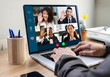 © Jose Carlos Cerdeno/ADDICTIVE STOCK - Crop anonymous businessman sitting at table with laptop in office and communicating with multiracial colleagues via video conference