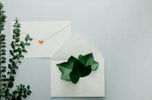 Minimal Composition With A White Envelope, Heart And Green Leaves