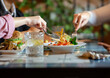 © Jose Carlos Cerdeno/ADDICTIVE STOCK - Group of crop anonymous friends gathering at table with various snacks and drinks while having dinner together in cozy restaurant