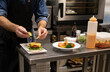 © Jose Carlos Cerdeno/ADDICTIVE STOCK - Crop unrecognizable male cook adding sliced fresh cucumber to hamburger with meat cutlet and cheese while preparing snack in restaurant kitchen