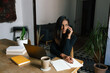 © Joy Zamora/ADDICTIVE STOCK - Busy ethnic female entrepreneur sitting at table in home office and speaking on cellphone about new startup project while working remotely and looking away