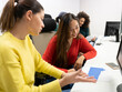 © Jose Carlos Cerdeno/ADDICTIVE STOCK - Positive multiracial women in casual clothes sitting at table with computer and discussing chart with results of marketing research  on paper while working together in modern coworking office