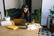 © Joy Zamora/ADDICTIVE STOCK - Focused Indian female freelancer sitting at table and typing on laptop while working on project in cozy home office