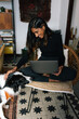 © Joy Zamora/ADDICTIVE STOCK - Delighted Indian female freelancer sitting on chair and working remotely from home with obedient Border Collie dog sitting nearby