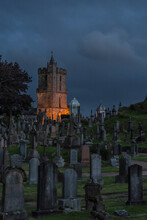 Scenery Of Aged Cemetery With Old Tombstones Located Near Castle In Dark Evening In Scotland