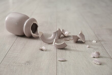 Broken Pink Ceramic Vase On Wooden Floor
