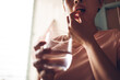 © Juan Alberto Ruiz/ADDICTIVE STOCK - Crop unrecognizable female with glass of fresh water taking yellow vitamin pill while representing healthy lifestyle concept