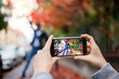 © Halfpoint - Young couple with smartphone making video for social media outdoors on street.