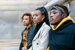 © Julio Rodriguez/ADDICTIVE STOCK - Serious unemotional young African American friends in casual informal clothes standing on stairway looking away while spending time together in city