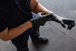 © Manuel Ruiz/ADDICTIVE STOCK - From above anonymous male employee putting on latex gloves during work in garage