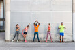 © Manuel Ruiz/ADDICTIVE STOCK - Group of multiracial runners in activewear standing in street and stretching muscles while preparing for training in city