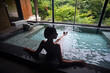 © Nano Calvo/ADDICTIVE STOCK - Silhouette of young caucasian woman enjoying.a relaxing thermal waters bath at a traditional Japanese onsen ryokan, view from behind