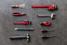 Top View Of Shabby Metal Repair Tools Arranged In Rows On Floor Of Garage