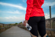 © Oscar De Dios/ADDICTIVE STOCK - Cropped unrecognizable female athlete holding plastic bottle with fresh water standing on wooden promenade