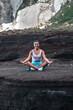 © Pablo Garcia/ADDICTIVE STOCK - Peaceful female sitting in Lotus pose with mudra hands and meditating while doing yoga and practicing mindfulness on beach near sea