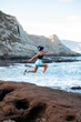© Pablo Garcia/ADDICTIVE STOCK - Side view of athletic female jumping high above ground while doing active cardio workout near sea in summer
