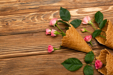 Wall Mural - top view of pink flowers in waffle cones on wooden surface