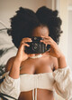 © Oscar De Dios/ADDICTIVE STOCK - Unrecognizable African American female photographer taking shots with vintage instant photo camera