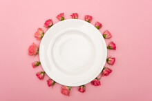 Flat Lay With White Plate And Tea Roses Isolated On Pink