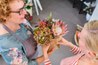 © Philippe Degroote/ADDICTIVE STOCK - From above of female florist in apron selling bunch of various flowers in paper bag for customer in floral shop