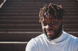 © Philippe Degroote/ADDICTIVE STOCK - Happy African American young male sitting in staircase on street relaxing looking at camera