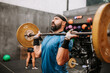 © Raquel Arocena/ADDICTIVE STOCK - Side view of muscular male athlete doing clean and jerk exercise while training in modern fitness center