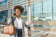 © Philippe Degroote/ADDICTIVE STOCK - Cheerful African American female entrepreneur in smart casual outfit and with suitcase standing in airport and speaking on smartphone