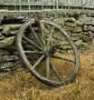 Old wooden wheel based on a stone fence.