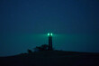 © Sergey Mironov/ADDICTIVE STOCK - Beacon tower located on hill and illuminating darkness with green light on background of starry night sky