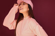 © Victor Torres/ADDICTIVE STOCK - Portrait of happy young asian woman in the studio wearing pink clothes over garnet background