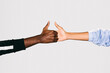 © Victor Torres/ADDICTIVE STOCK - Close-up of a black man's hand holding a white woman's hand over white background