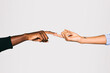 © Victor Torres/ADDICTIVE STOCK - Close-up of a black man' touching white woman's finger over white background